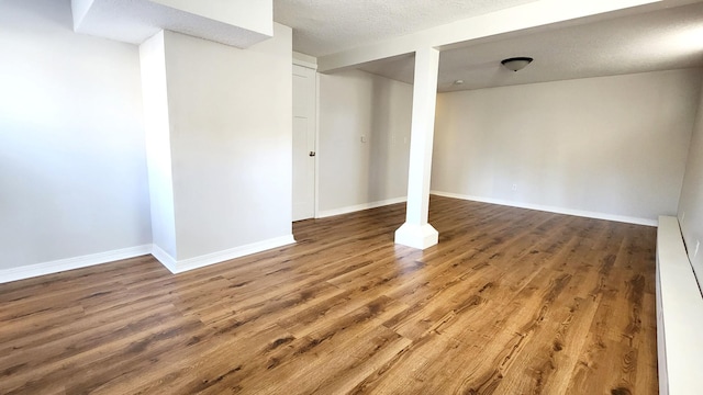 basement with hardwood / wood-style floors and a textured ceiling