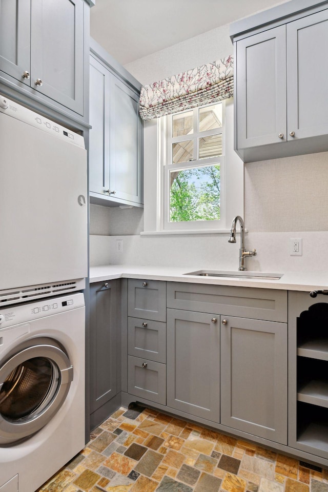 laundry room featuring estacked washer and dryer and cabinet space