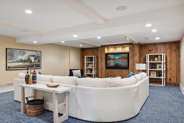 living area with dark colored carpet, beamed ceiling, recessed lighting, wooden walls, and baseboards
