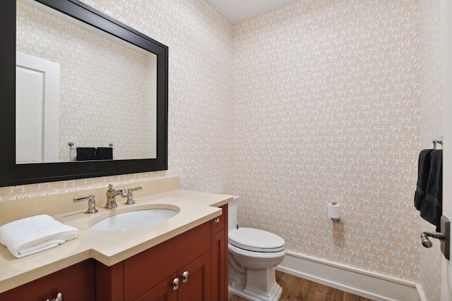bathroom featuring wood finished floors, toilet, and vanity