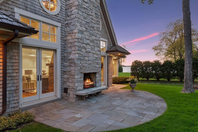 view of patio with french doors and an outdoor stone fireplace