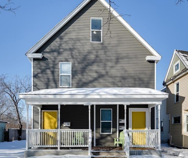 rear view of property featuring covered porch