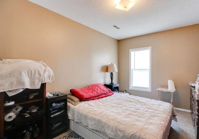 bedroom with carpet floors and a textured ceiling