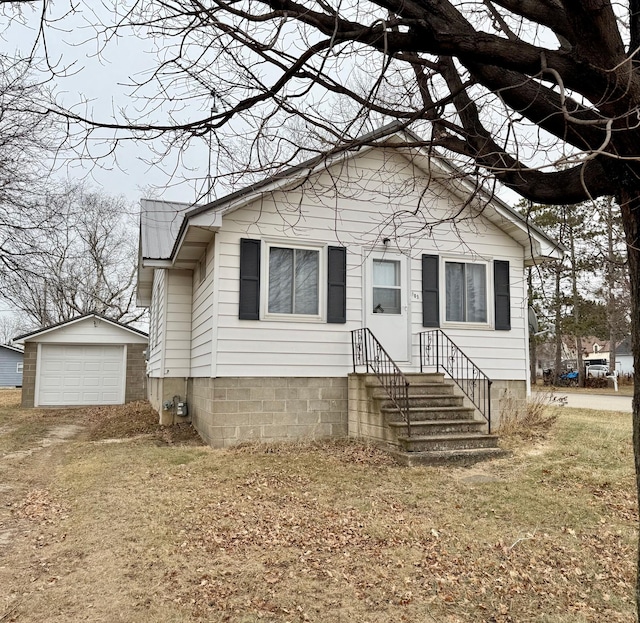 view of front of home featuring a garage, an outdoor structure, and a front yard