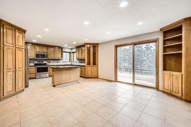 kitchen with a kitchen breakfast bar, decorative backsplash, a center island, light tile patterned floors, and stainless steel appliances