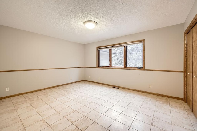 unfurnished room with a textured ceiling