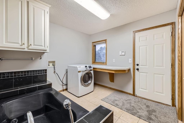 washroom with cabinets, washer / dryer, a textured ceiling, and light tile patterned floors