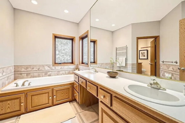 bathroom with vanity, a tub to relax in, tile patterned floors, and toilet