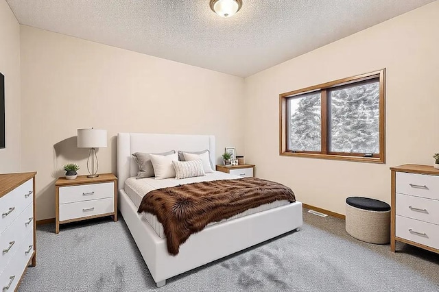 bedroom with carpet floors and a textured ceiling