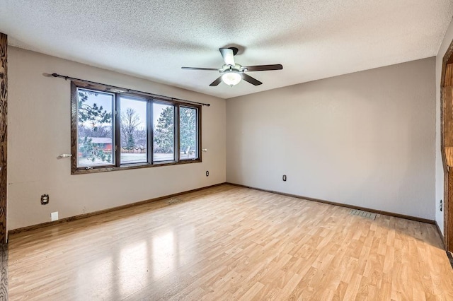 empty room with ceiling fan, light hardwood / wood-style flooring, and a textured ceiling