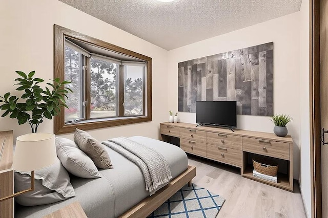 bedroom featuring a textured ceiling and light hardwood / wood-style floors