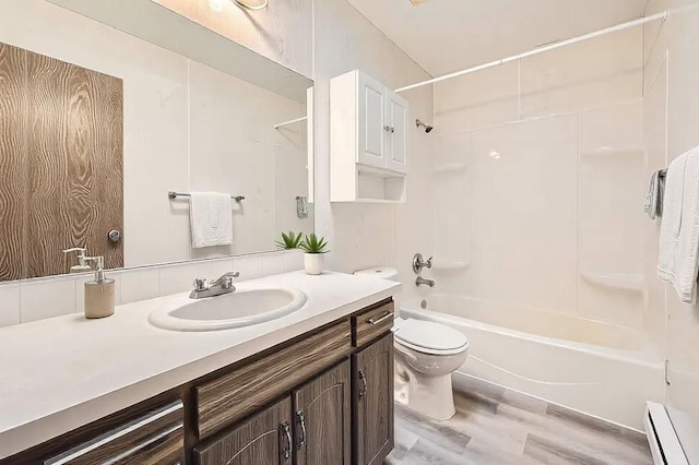 full bathroom featuring a baseboard heating unit, vanity, wood-type flooring, bathtub / shower combination, and toilet