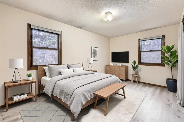 bedroom with light hardwood / wood-style floors and a textured ceiling