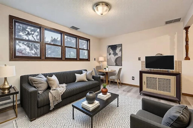 living room with light hardwood / wood-style floors and a textured ceiling