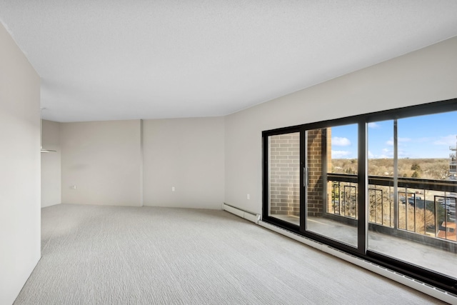 unfurnished room featuring a baseboard heating unit and carpet flooring