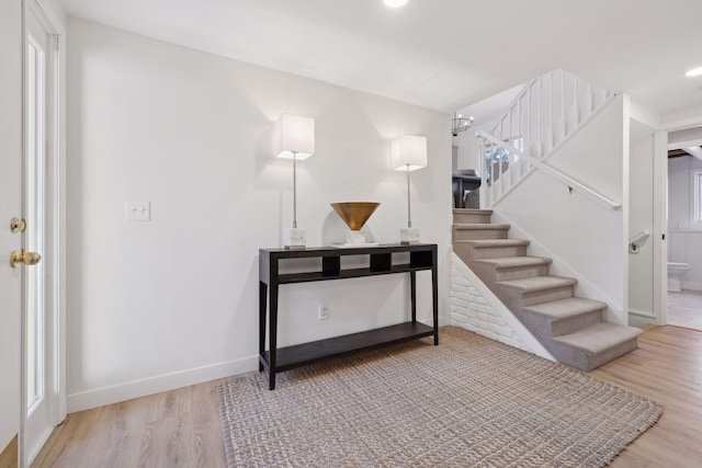 stairway featuring hardwood / wood-style flooring and an inviting chandelier