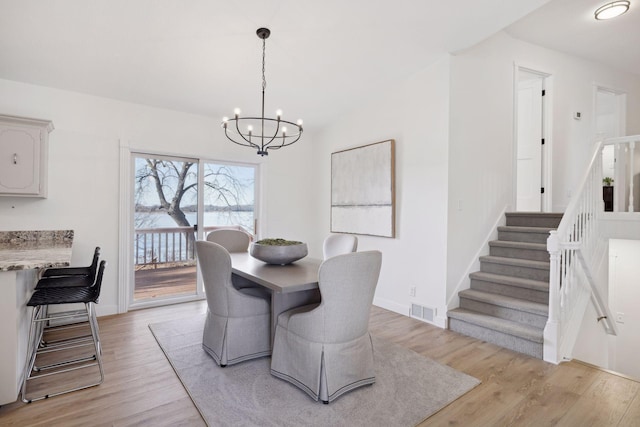 dining space with an inviting chandelier and light hardwood / wood-style floors