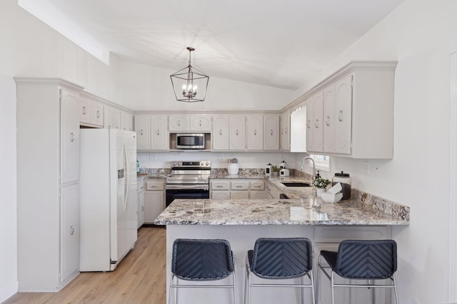 kitchen with sink, appliances with stainless steel finishes, decorative light fixtures, vaulted ceiling, and kitchen peninsula