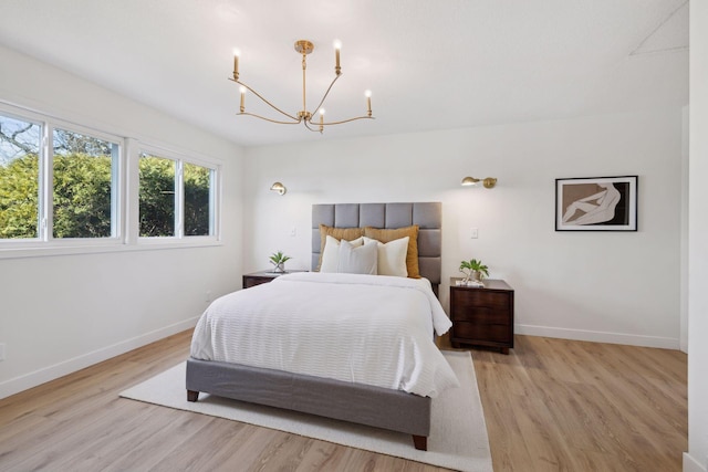 bedroom with a notable chandelier and light hardwood / wood-style flooring