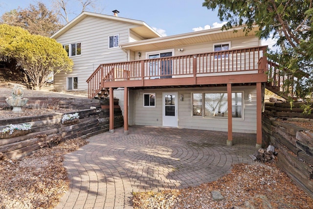 back of house with a wooden deck and a patio