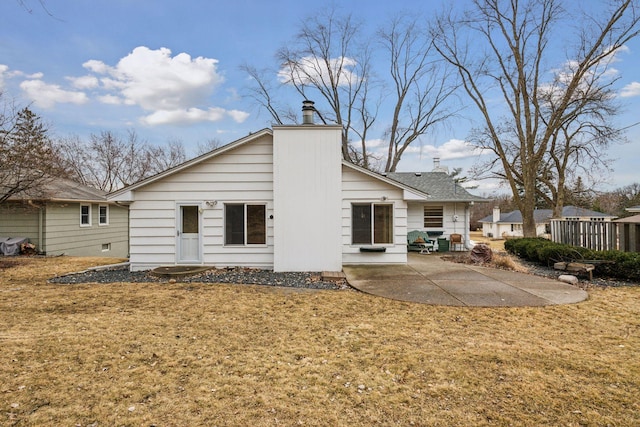 rear view of property with a patio and a lawn