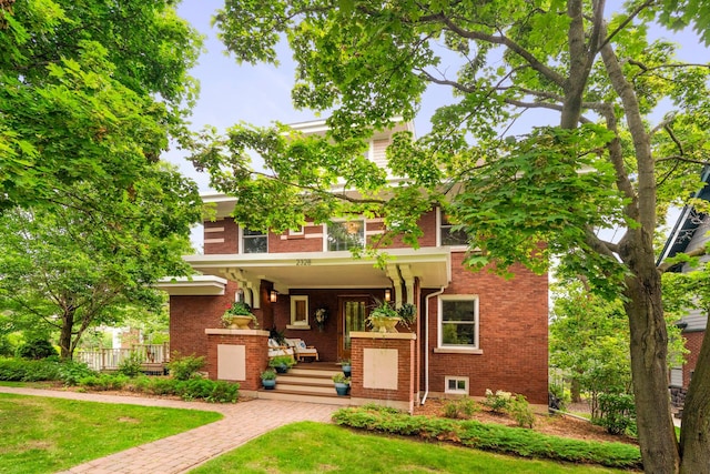 2328 3rd St, Duluth, MN 55812 - view of front of house featuring covered porch, brick siding, and a front yard