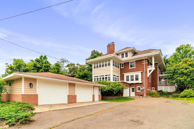 2328 3rd St, Duluth, MN 55812 - view of front facade with brick siding, a detached garage, a chimney, and an outdoor structure