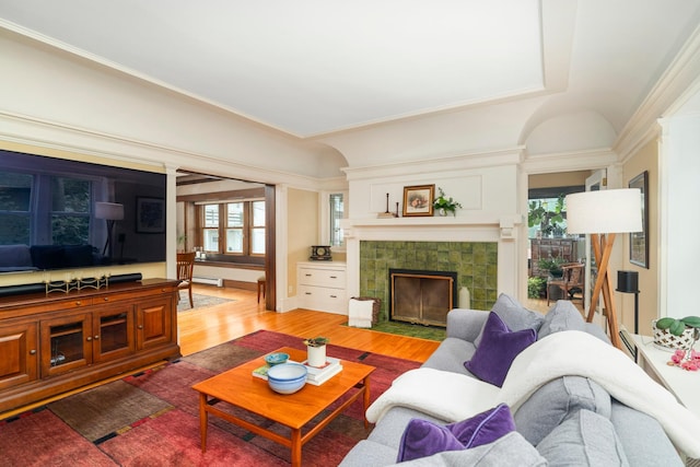 2328 3rd St, Duluth, MN 55812 - living room with wood finished floors, a tiled fireplace, crown molding, and baseboard heating