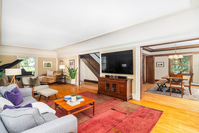 2328 3rd St, Duluth, MN 55812 - living room featuring stairway, light wood-style floors, a chandelier, and crown molding
