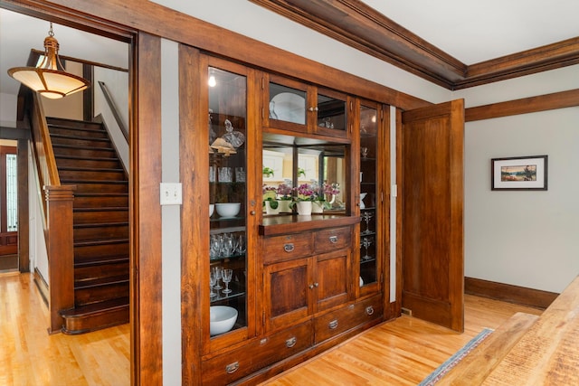 2328 3rd St, Duluth, MN 55812 - bar featuring ornamental molding, light wood-style floors, stairs, and hanging light fixtures