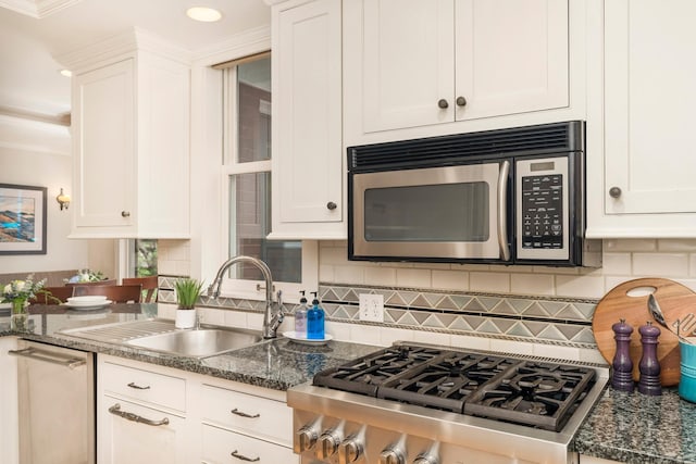 2328 3rd St, Duluth, MN 55812 - kitchen with appliances with stainless steel finishes, white cabinets, tasteful backsplash, dark stone countertops, and recessed lighting