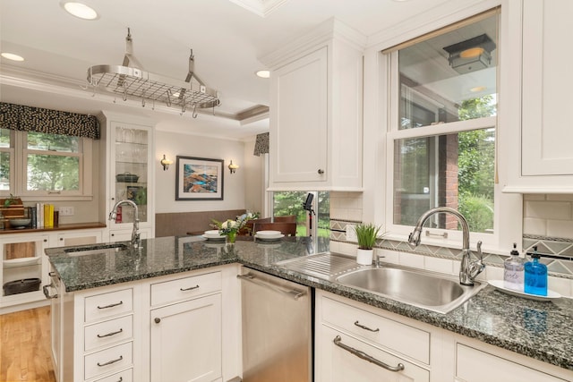 2328 3rd St, Duluth, MN 55812 - kitchen featuring stainless steel dishwasher, crown molding, a peninsula, white cabinets, and backsplash