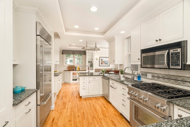 2328 3rd St, Duluth, MN 55812 - kitchen featuring high quality appliances, a peninsula, light wood finished floors, recessed lighting, and white cabinetry