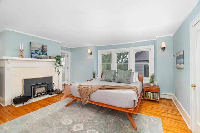2328 3rd St, Duluth, MN 55812 - bedroom with wood finished floors, ornamental molding, a baseboard heating unit, and a tile fireplace