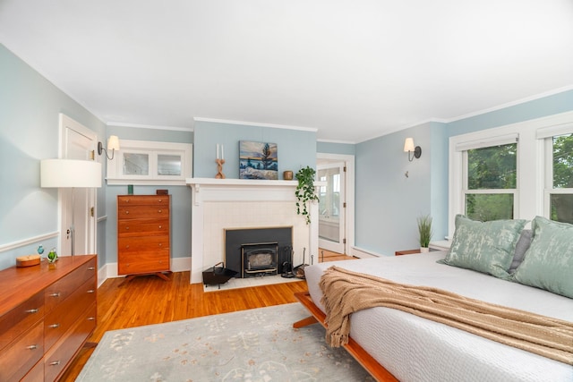 2328 3rd St, Duluth, MN 55812 - bedroom featuring wood finished floors, a wood stove, and ornamental molding