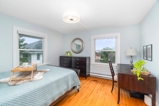 2328 3rd St, Duluth, MN 55812 - bedroom featuring a baseboard radiator, multiple windows, and light wood-style floors