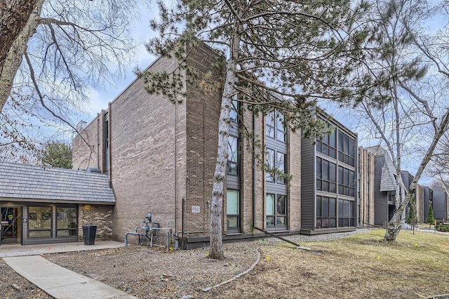 view of property exterior featuring a patio area and brick siding