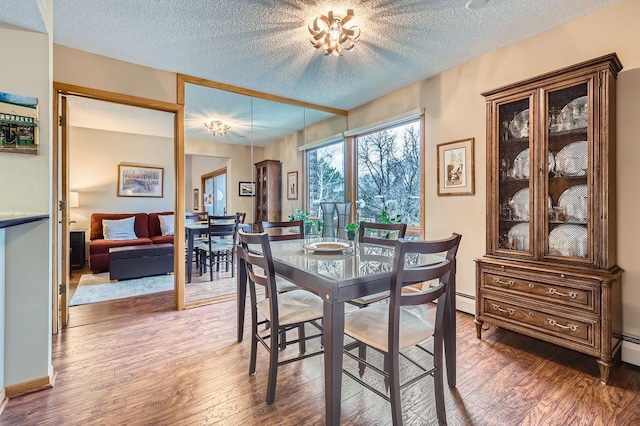 dining space with a textured ceiling and wood finished floors