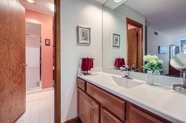 full bathroom featuring a textured ceiling, tile patterned flooring, visible vents, vanity, and a stall shower