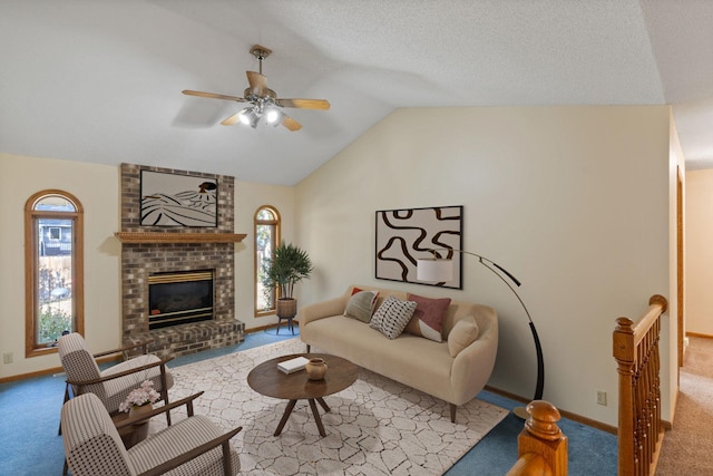 carpeted living room featuring ceiling fan, a fireplace, and vaulted ceiling