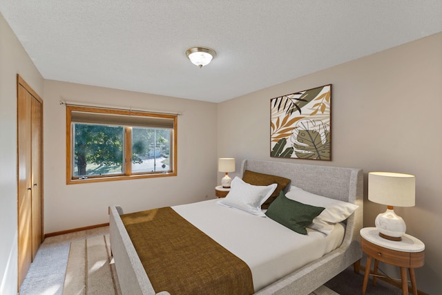 bedroom featuring carpet flooring, a textured ceiling, and a closet