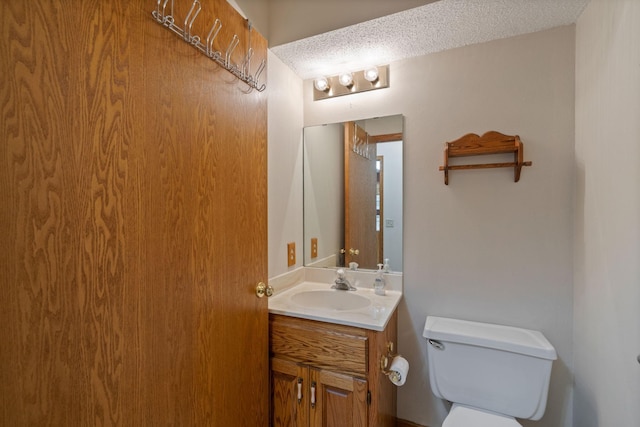 bathroom with vanity, a textured ceiling, and toilet