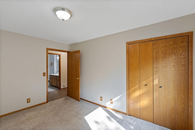 unfurnished bedroom with light colored carpet, a textured ceiling, and a closet