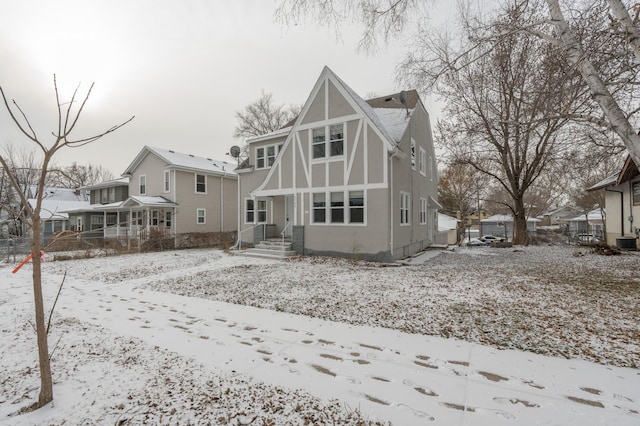 snow covered rear of property with cooling unit