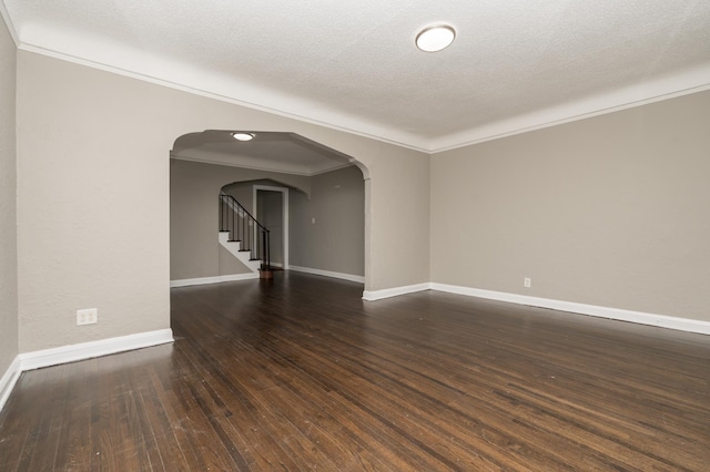 spare room featuring dark hardwood / wood-style flooring, ornamental molding, and a textured ceiling