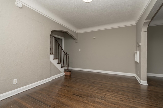 interior space featuring dark hardwood / wood-style flooring, ornamental molding, and a textured ceiling