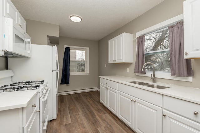 kitchen with a textured ceiling, white appliances, dark wood-type flooring, sink, and white cabinetry