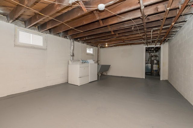 basement featuring water heater and independent washer and dryer