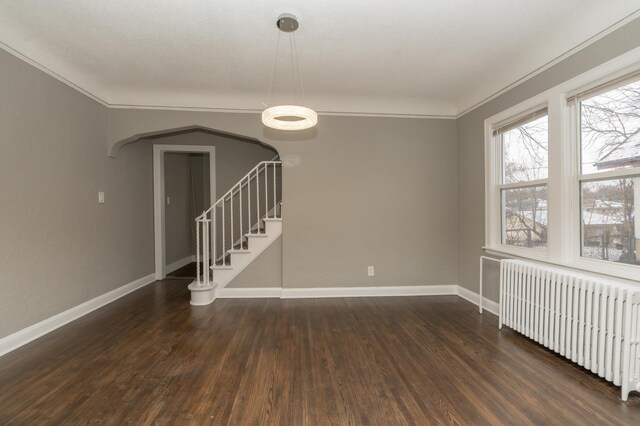 unfurnished room featuring radiator heating unit, dark hardwood / wood-style floors, and crown molding