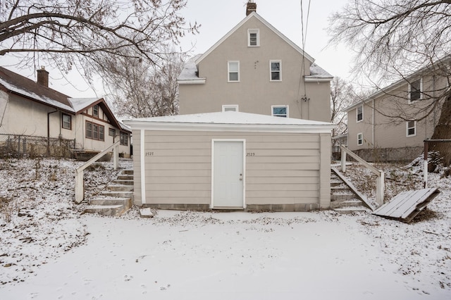 snow covered house featuring an outdoor structure